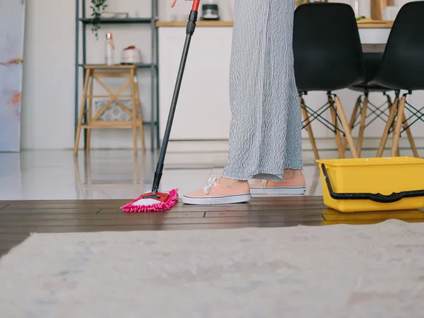 Mopping the floor with a mop and bucket